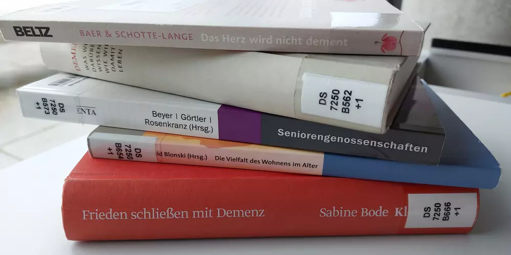 5 books on the subject of dementia are lying on a table.